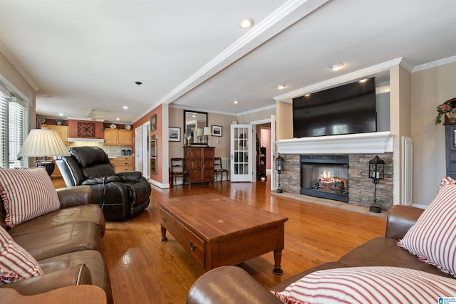 living room with ornamental molding, light hardwood / wood-style flooring, and a fireplace