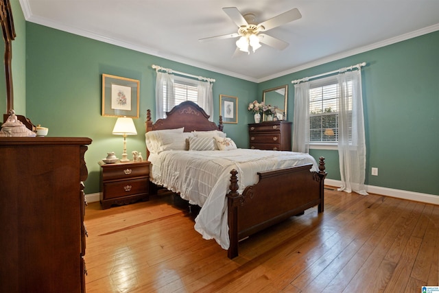 bedroom with crown molding, light hardwood / wood-style floors, and ceiling fan