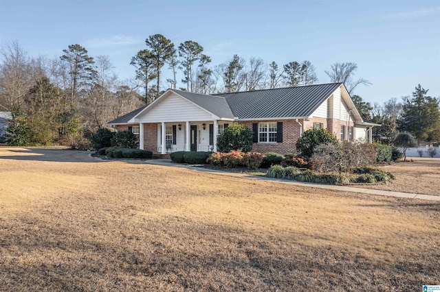 ranch-style home featuring covered porch and a front lawn