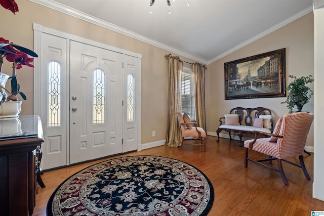 foyer with wood-type flooring, lofted ceiling, and crown molding