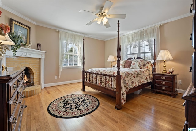 bedroom with ceiling fan, light hardwood / wood-style flooring, a brick fireplace, and ornamental molding