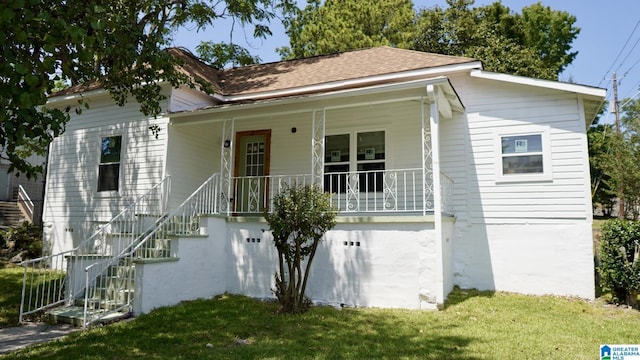 view of front facade with covered porch and a front lawn