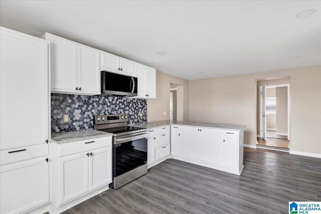 kitchen with dark hardwood / wood-style floors, tasteful backsplash, white cabinets, kitchen peninsula, and stainless steel appliances