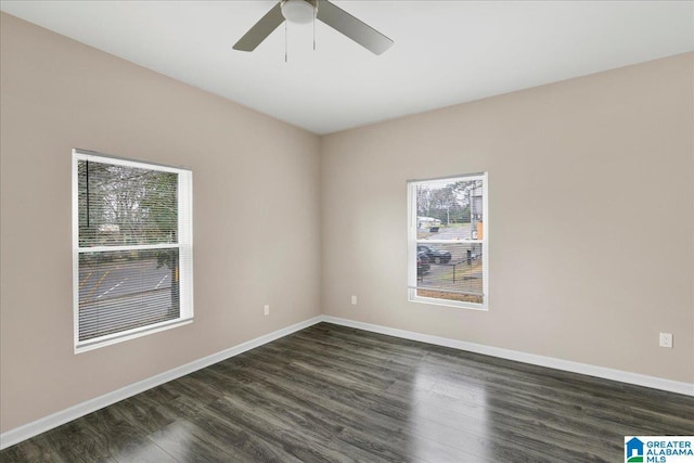 empty room featuring dark wood-type flooring and ceiling fan