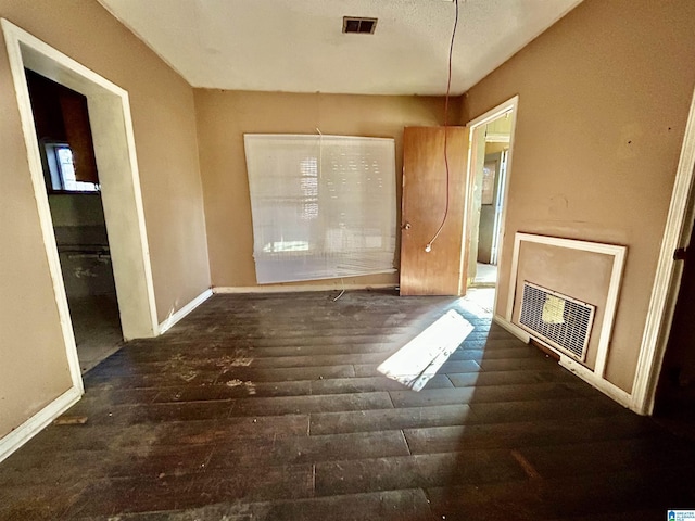 interior space featuring heating unit and dark hardwood / wood-style flooring