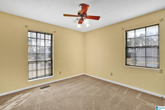 spare room featuring ceiling fan, a textured ceiling, and carpet flooring