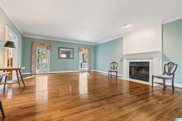 unfurnished living room featuring a high end fireplace, ornamental molding, and wood-type flooring