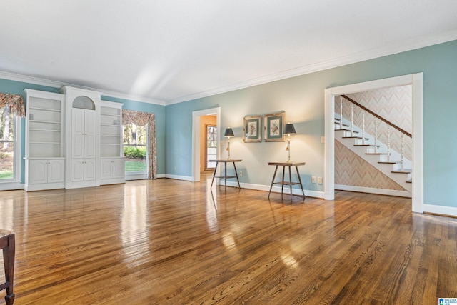 unfurnished living room featuring hardwood / wood-style floors and ornamental molding