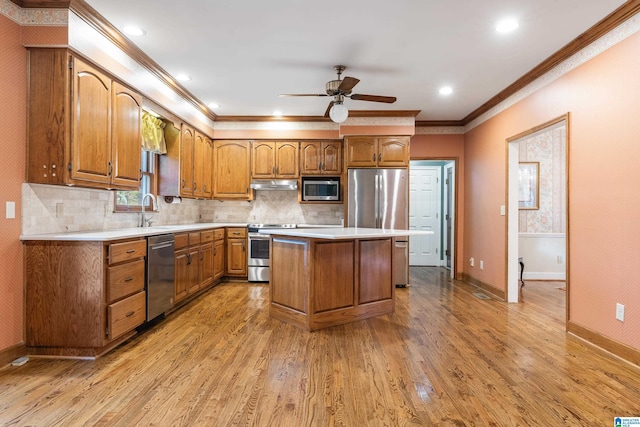 kitchen with stainless steel appliances, a kitchen island, light hardwood / wood-style flooring, and decorative backsplash