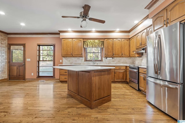 kitchen with light wood-type flooring, stainless steel appliances, a center island, and tasteful backsplash