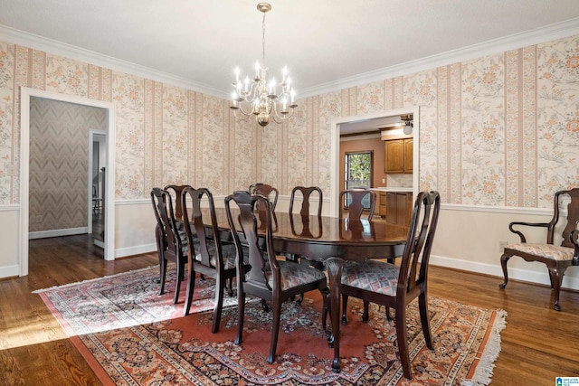 dining area with dark hardwood / wood-style flooring, a notable chandelier, and ornamental molding