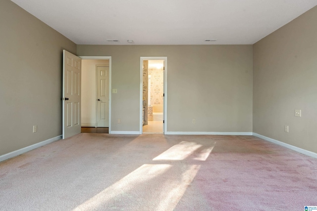 unfurnished bedroom with light carpet and ensuite bathroom