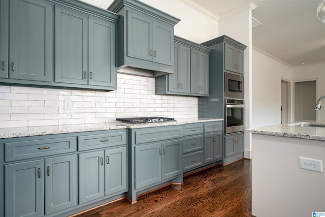 kitchen featuring sink, crown molding, dark wood-type flooring, and stainless steel appliances