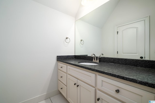 bathroom featuring tile patterned floors, lofted ceiling, and vanity