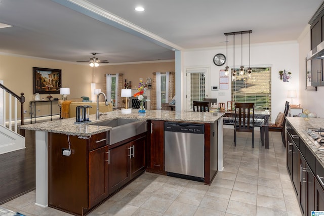 kitchen featuring crown molding, dishwasher, sink, decorative light fixtures, and an island with sink