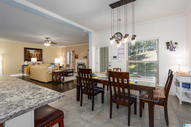 dining area featuring ceiling fan with notable chandelier and crown molding