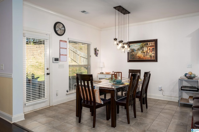 dining space with tile patterned floors, crown molding, and a notable chandelier