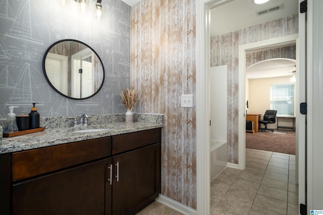 bathroom featuring a tub to relax in, tile patterned flooring, ceiling fan, and vanity