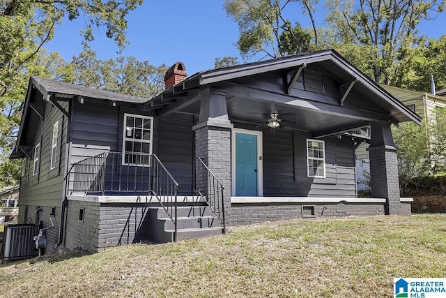 view of front facade with covered porch, ceiling fan, and a front yard