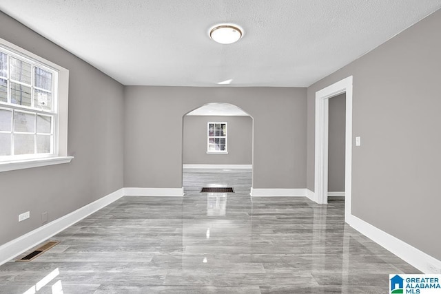 unfurnished room with a textured ceiling