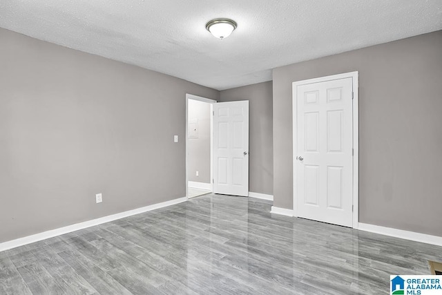 unfurnished bedroom with light hardwood / wood-style floors and a textured ceiling