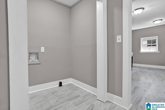 clothes washing area featuring a textured ceiling