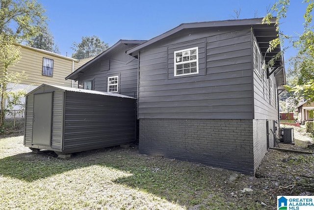 back of property with a storage unit, cooling unit, and a yard