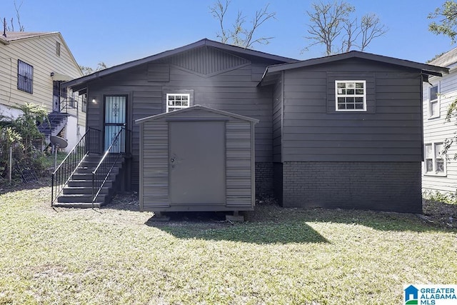 back of house featuring a lawn and a shed