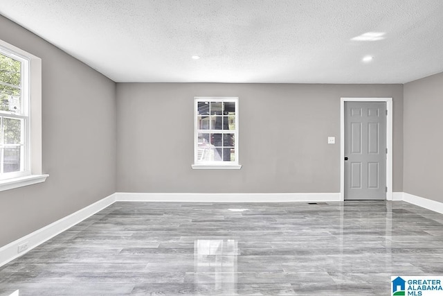 unfurnished room with a textured ceiling