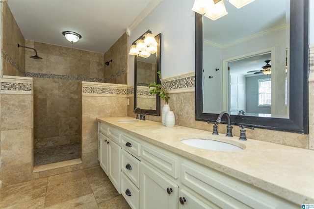 bathroom featuring crown molding, tiled shower, vanity, and tile walls