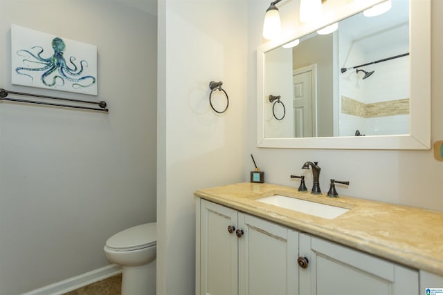 bathroom featuring tiled shower, vanity, and toilet