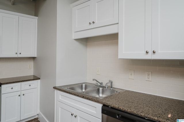 kitchen featuring tasteful backsplash, dishwasher, white cabinetry, sink, and dark stone counters