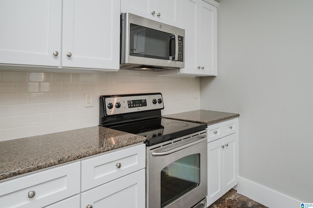 kitchen featuring white cabinets, dark stone counters, appliances with stainless steel finishes, and tasteful backsplash