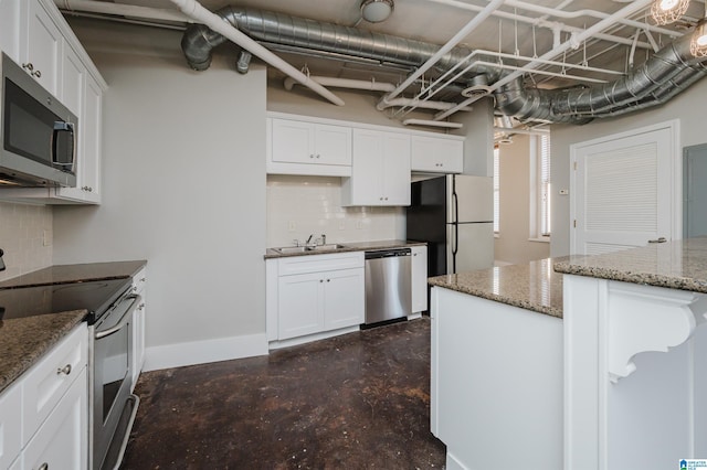 kitchen featuring tasteful backsplash, dark stone counters, white cabinets, sink, and stainless steel appliances