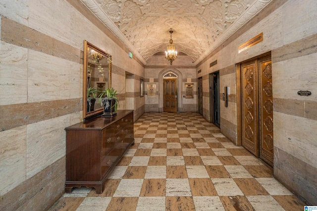 corridor featuring brick ceiling, a chandelier, and vaulted ceiling