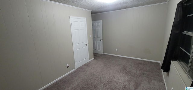 unfurnished bedroom with a textured ceiling, crown molding, and carpet flooring