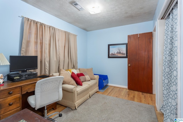 office area featuring a textured ceiling and light hardwood / wood-style flooring