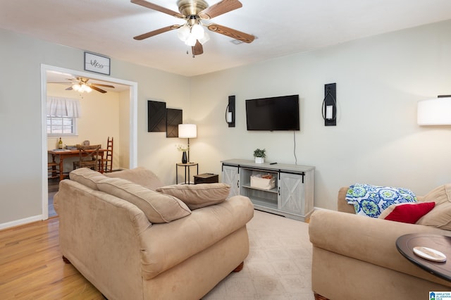 living room with light hardwood / wood-style flooring and ceiling fan