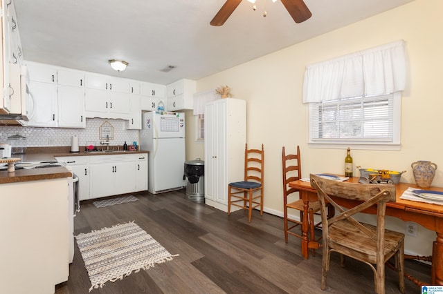 kitchen featuring sink, backsplash, white cabinetry, dark hardwood / wood-style floors, and white fridge