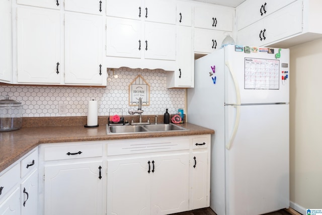 kitchen with sink, backsplash, white cabinetry, and white fridge