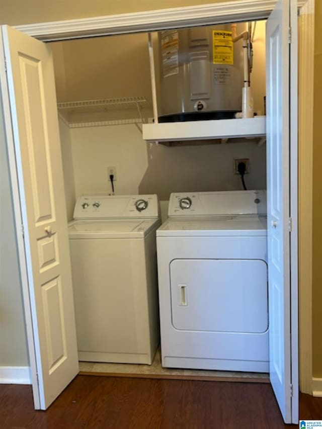 clothes washing area with dark wood-type flooring and washer and dryer