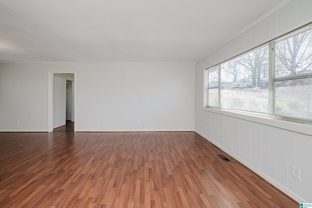 spare room featuring ornamental molding and dark hardwood / wood-style floors