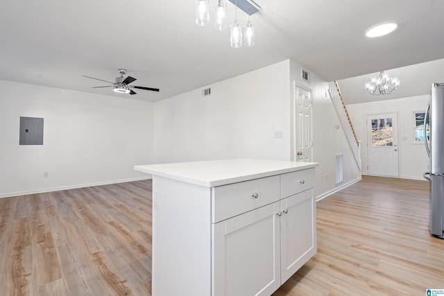 kitchen featuring a kitchen island, white cabinets, hanging light fixtures, electric panel, and light hardwood / wood-style flooring