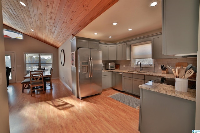 kitchen with light hardwood / wood-style floors, wooden ceiling, sink, stainless steel appliances, and light stone counters