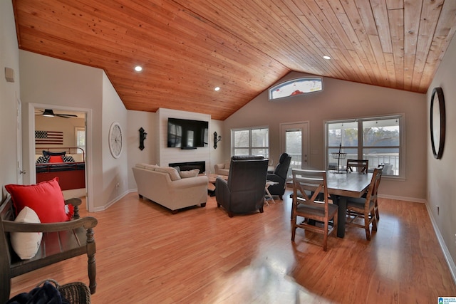 dining room with a large fireplace, light wood-type flooring, wooden ceiling, and lofted ceiling