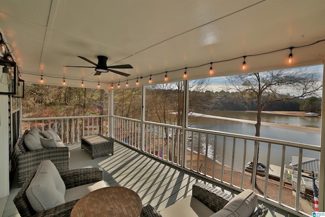 wooden deck with ceiling fan, an outdoor living space, and a water view