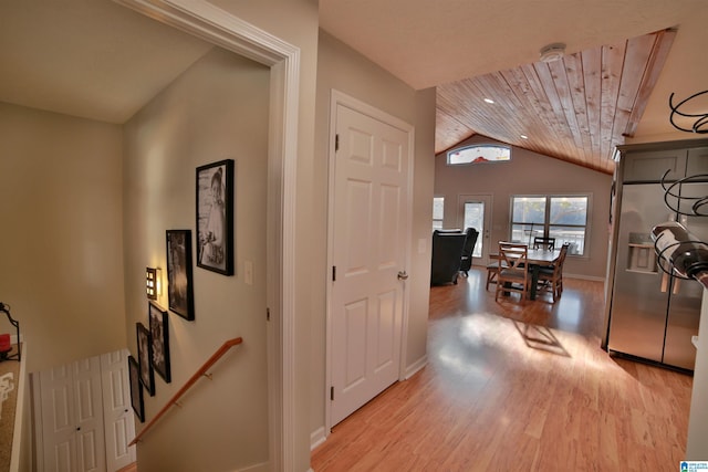 hall with light hardwood / wood-style flooring, wood ceiling, and vaulted ceiling