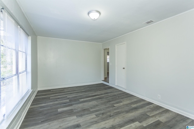 spare room featuring crown molding and dark hardwood / wood-style floors