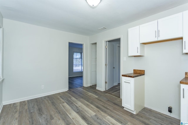 kitchen with white cabinetry, dark hardwood / wood-style floors, and butcher block countertops