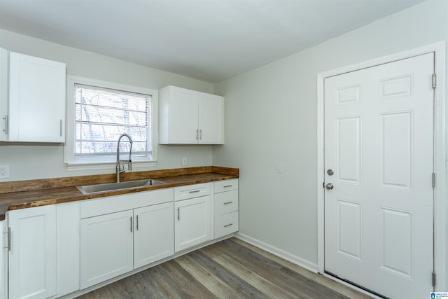 kitchen featuring sink, white cabinets, wood counters, and light hardwood / wood-style floors